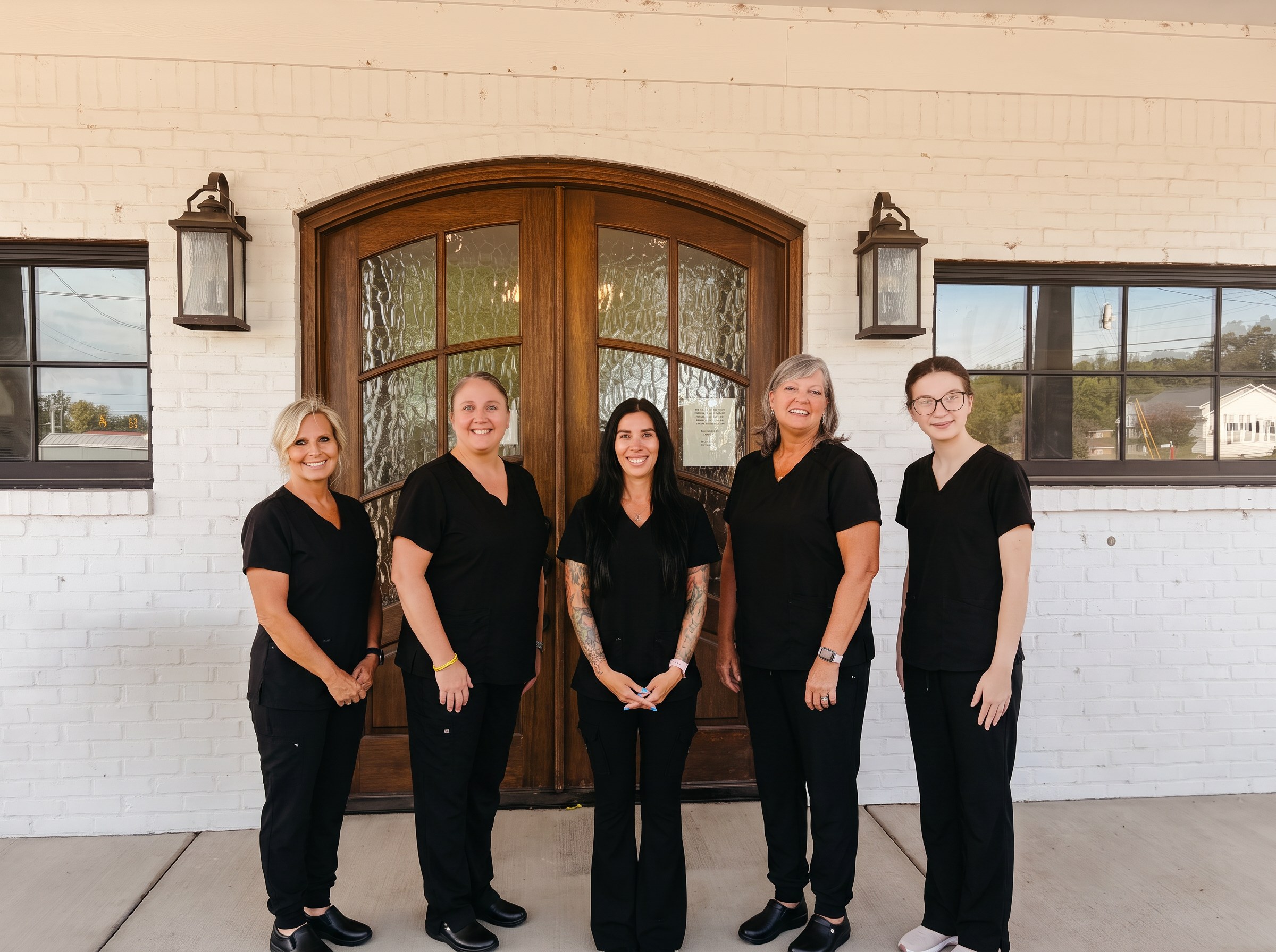 The Qualls Harbin Family Medicine team standing together at the clinic's front entrance.